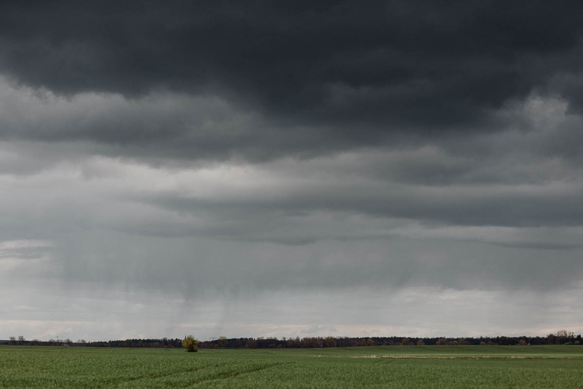 Gewitterstimmung mit Regen auf einem Feld - Verlobungsshooting trotz Regen