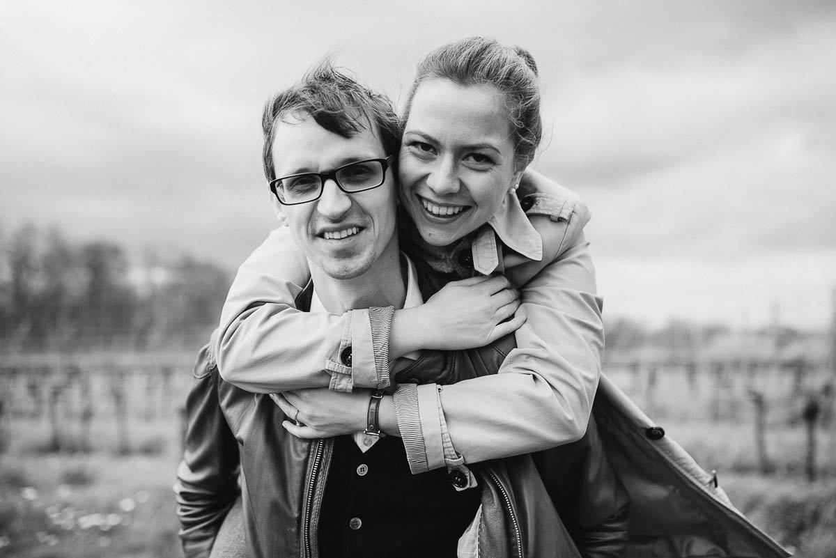 Verlobungsshooting mit einem Paar, das lachend in die Kamera schaut