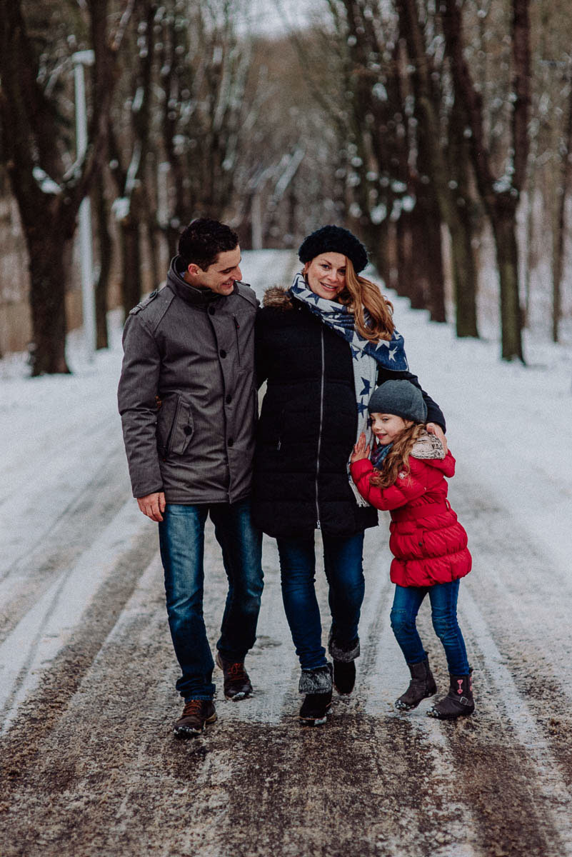Babybauch Shooting Familie geht im Winter mit Tochter spazieren