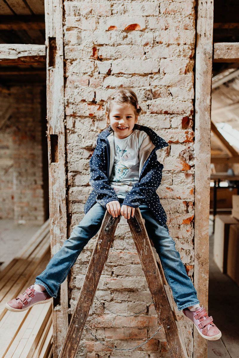Familien Fotoshooting Kind sitzt auf Leiter und lacht, Kinderfotos Fotografin Radebeul
