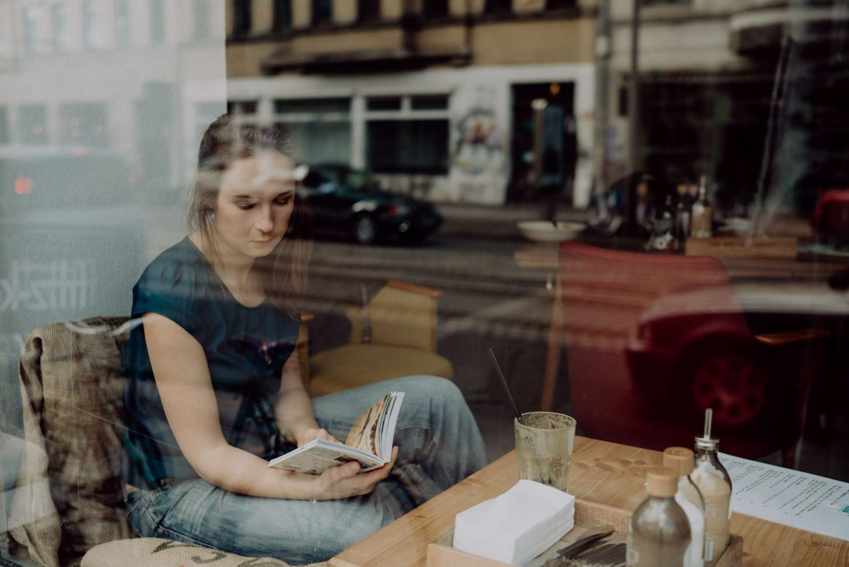 fotografin annelie brux portrait lesend im Café Scheibe Spiegelung