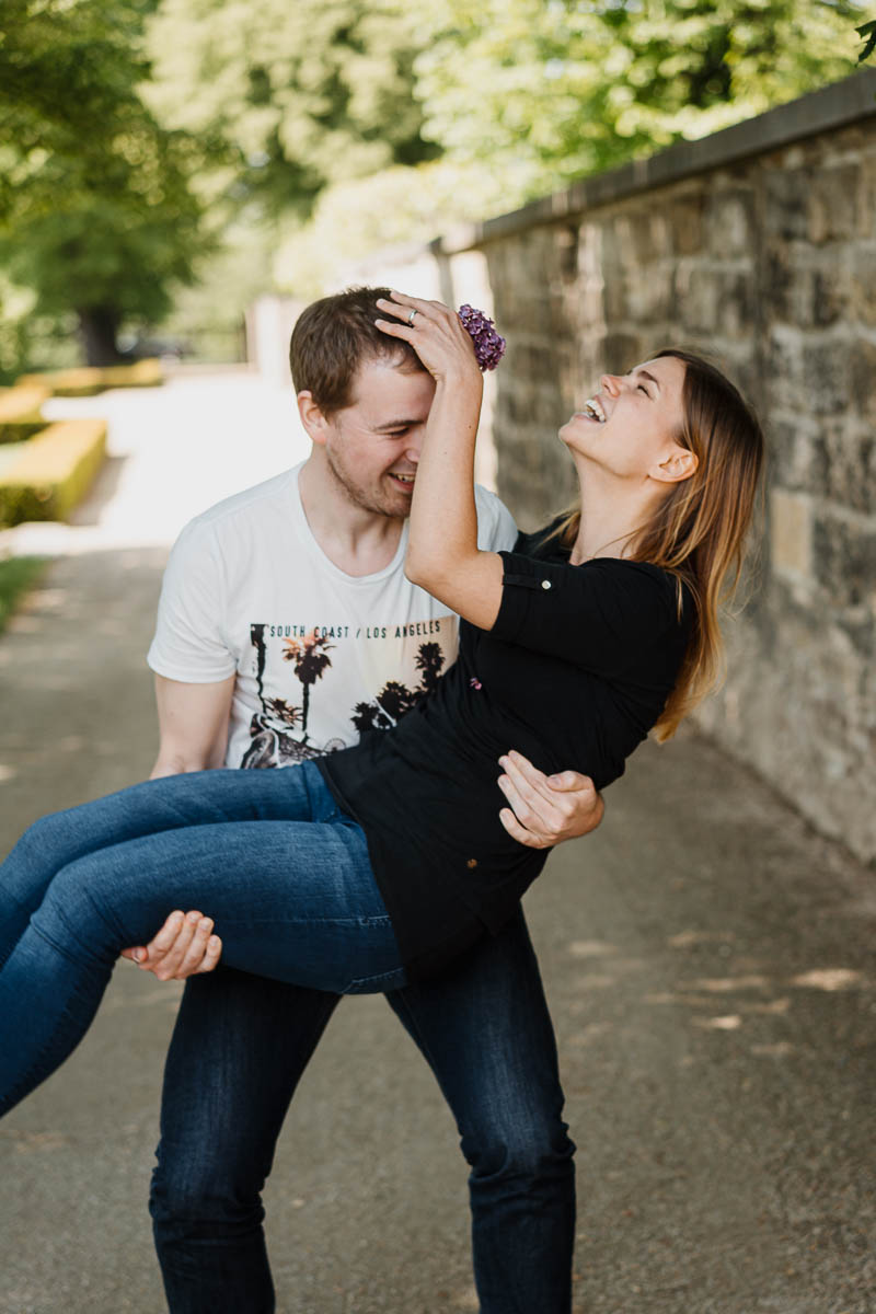ungestellte paarbilder annelie brux fotografie Mann trägt frau, sie lacht.