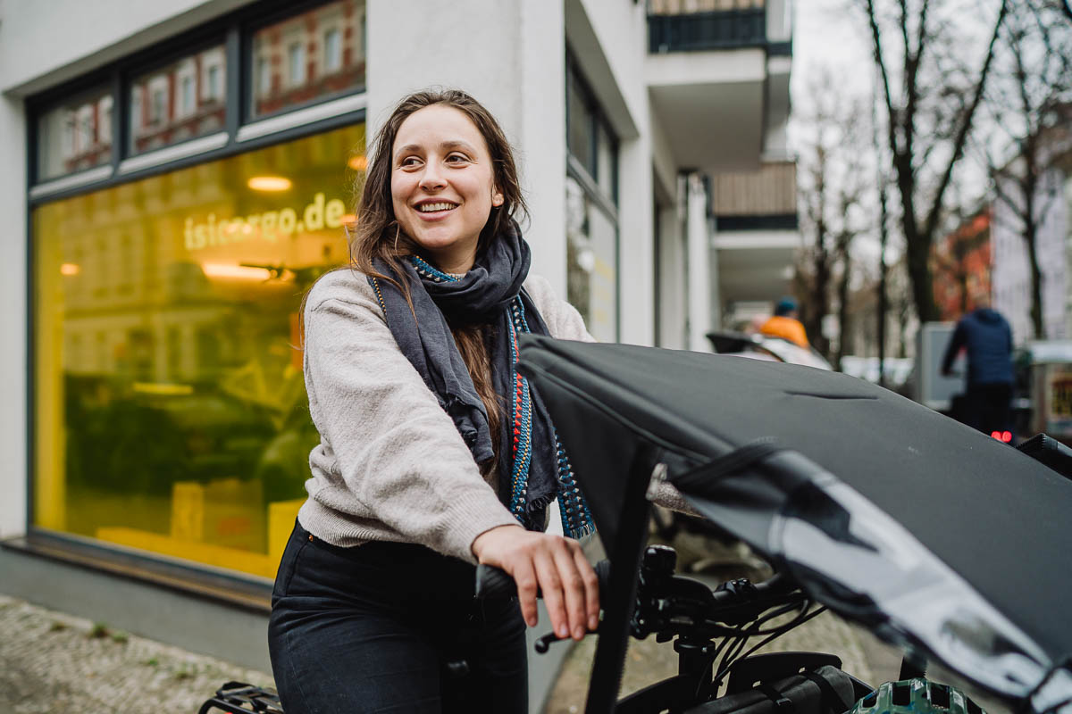 Businessfotografie für Unternehmen - eine Kundin macht mit einem Cargobike eine Probefahrt auf der Straße vor dem Laden.