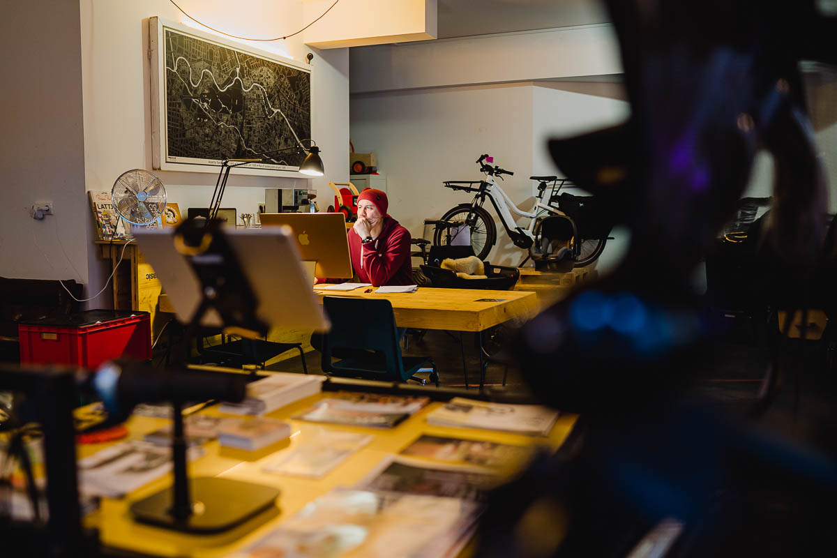 Authentische Unternehmensfotografie - Mitarbeiter arbeitet am Computer im Laden und bereitet einen Fahrradverkauf vor