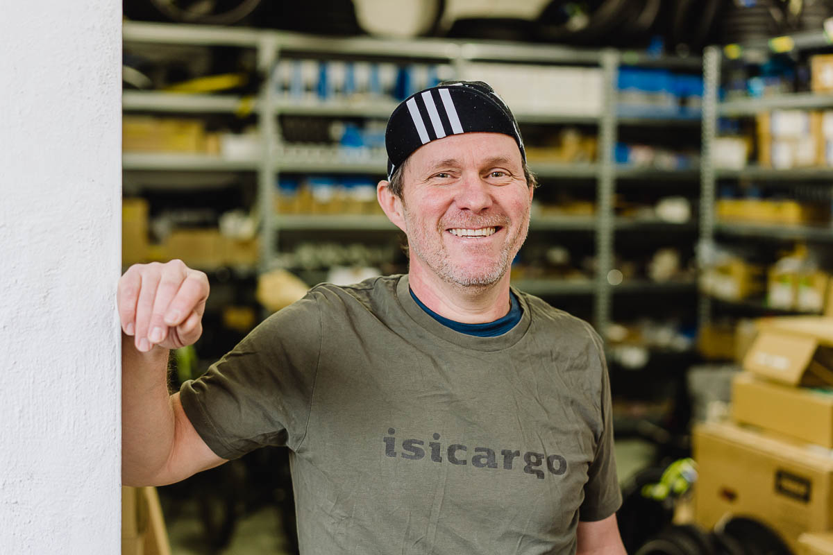 Businessfotografie Fahrradwerkstatt ein Mitarbeiter freut sich und lacht in die Kamera