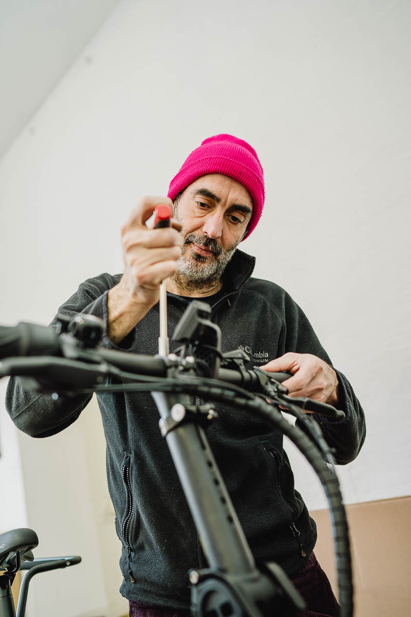 Unternehmensreportage Businessfotografie - ein Mechaniker repariert konzentriert ein Lastenrad