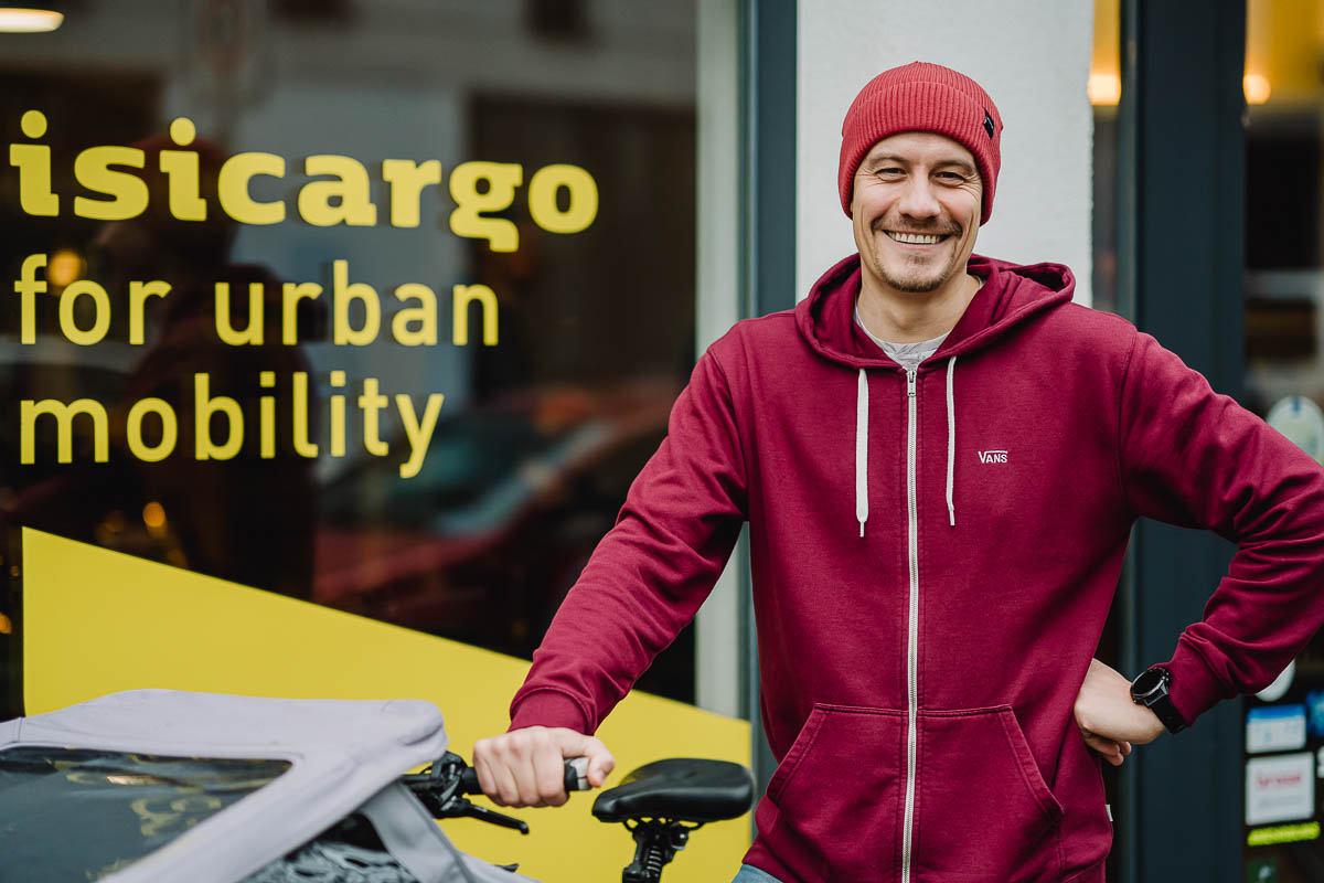 Mitarbeiterportrait vor dem Laden mit Bike und authentisch