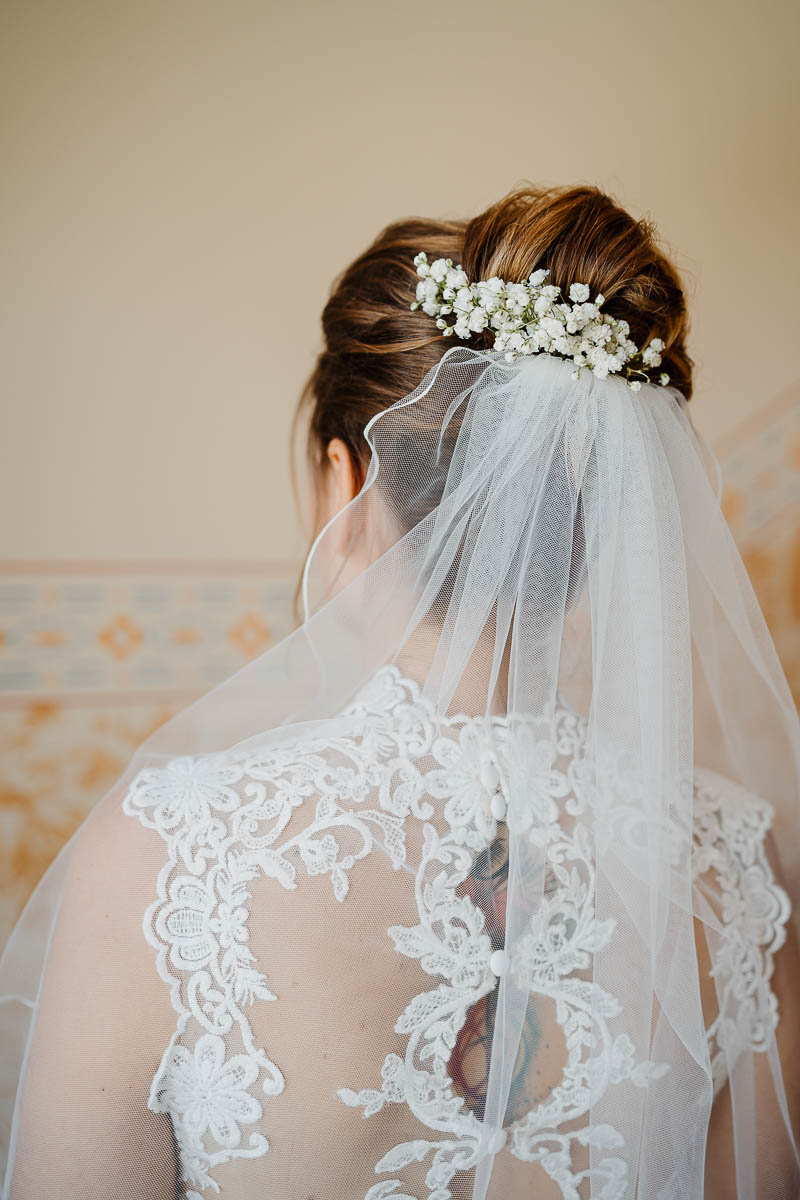 Als Hochzeitsfotograf Radebeul habe ich manchmal auch ganz praktische Aufgaben - die Braut kann sich nicht von hinten sehen. Da mache ich ein Bild von ihr und der Brautfrisur mit Schleier.