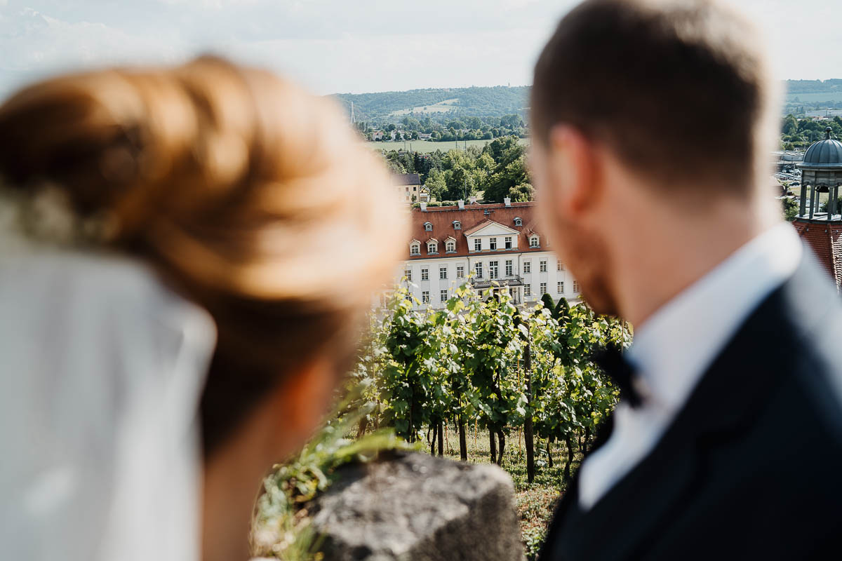 Bild beim Brautpaarshooting mit Blick vom Jacobstein in Radebeul auf Schloss Wackerbarth.