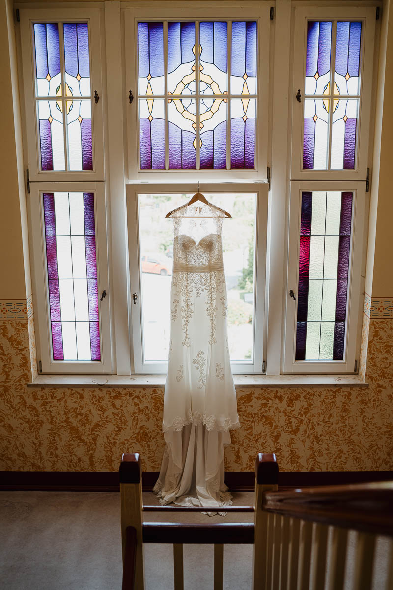 Das Brautkleid hängt im Treppenhaus - eines der wichtigsten Bilder beim Getting Ready bei einer Hochzeitsreportage Radebeul